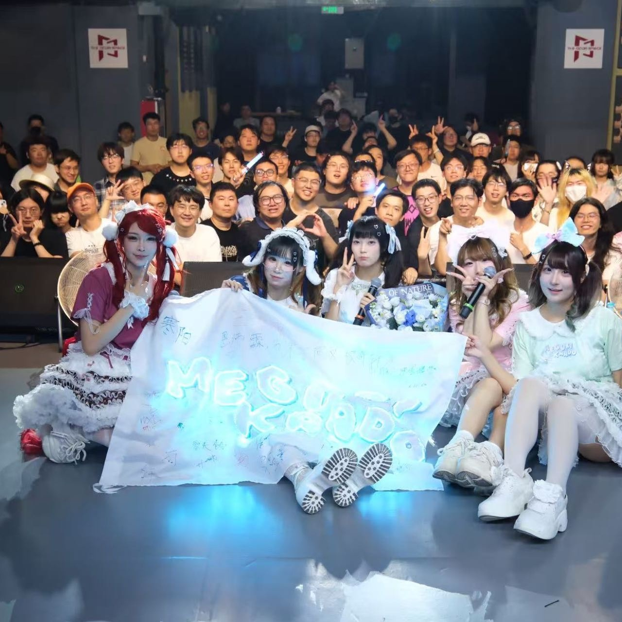 成员与观众的合照，前排展开写满名字的Meguri-Kaado签名旗